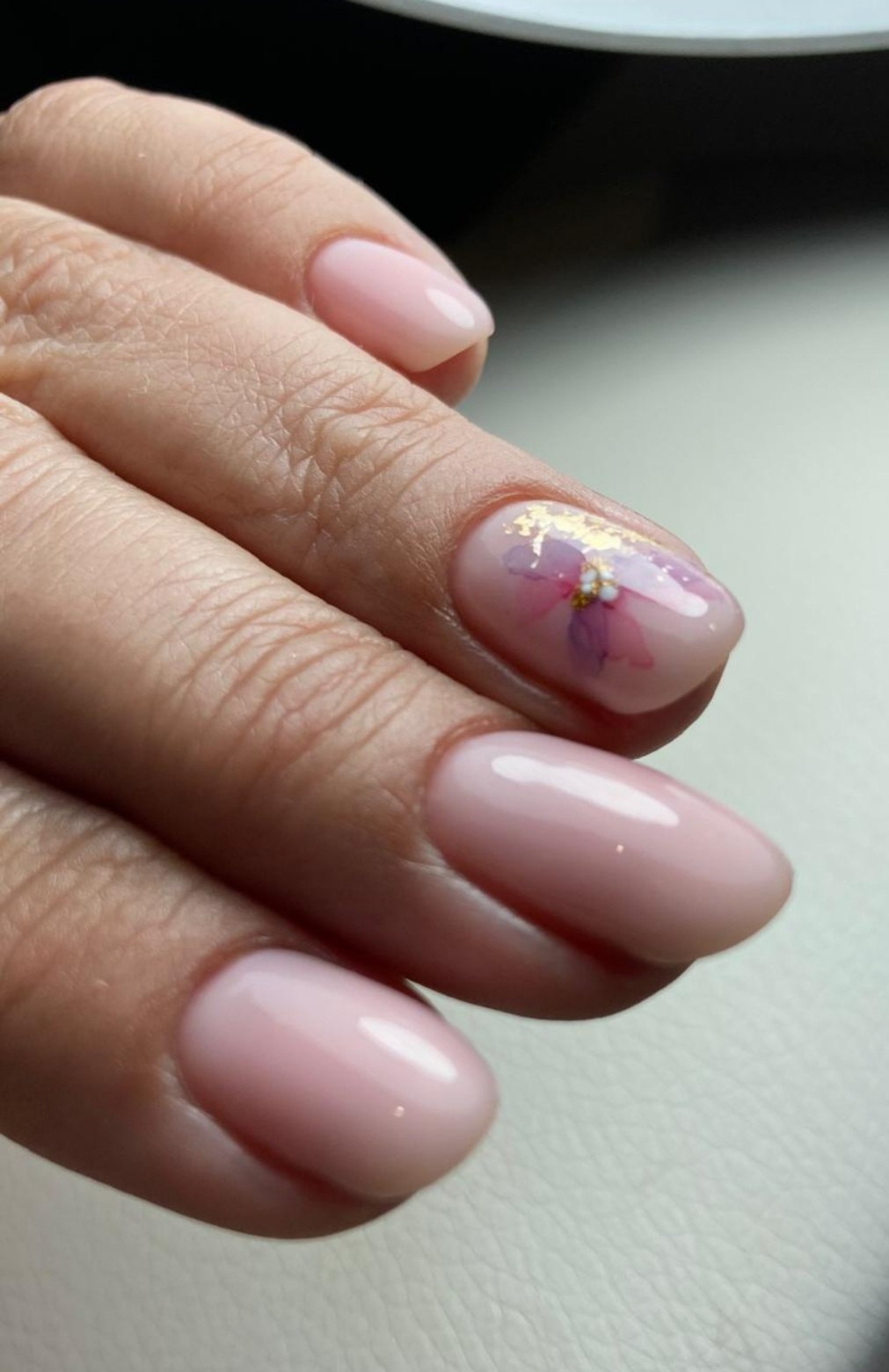 Nude manicure with floral and gold foil accent