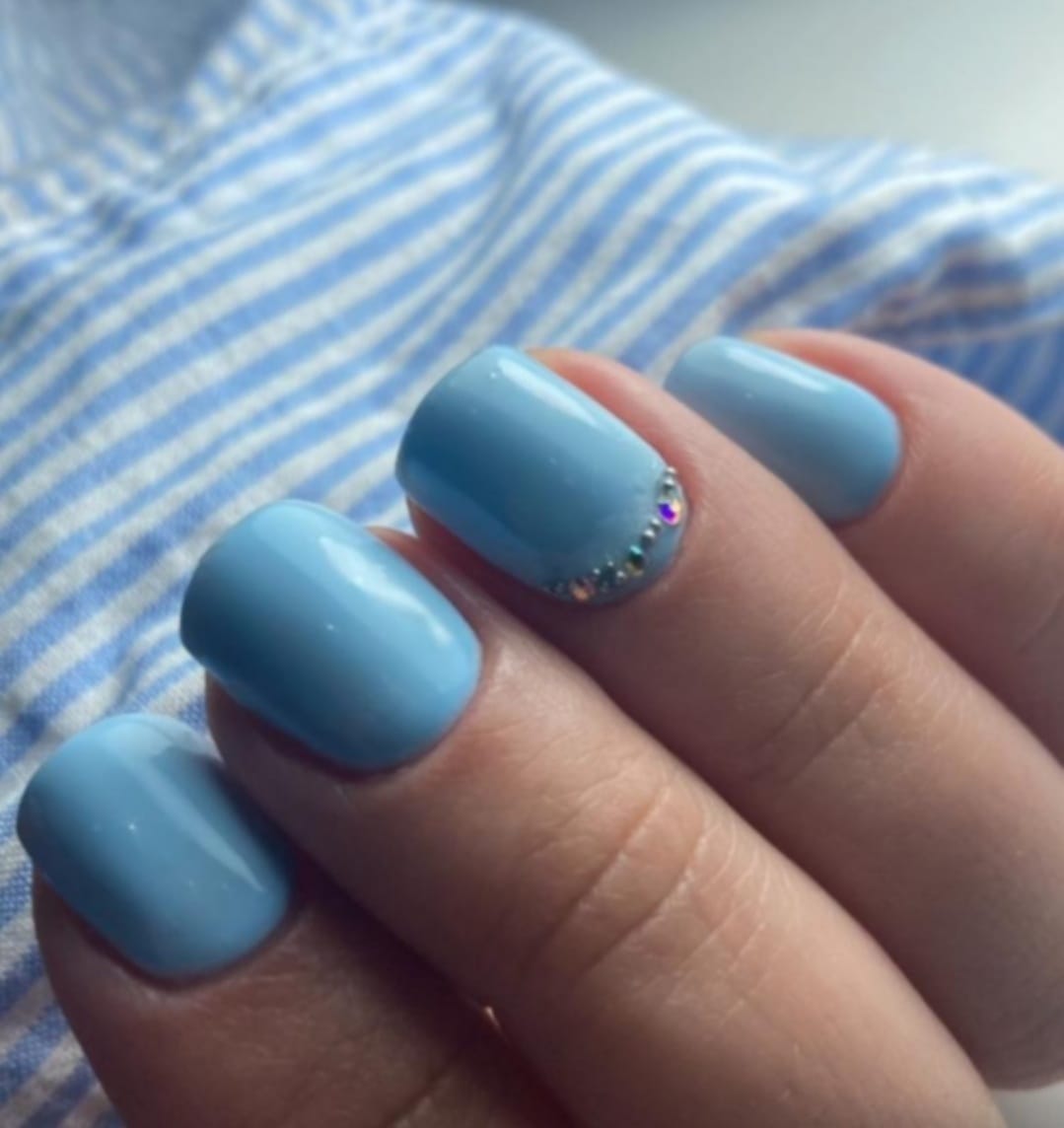 Light blue manicure with rhinestone accent
