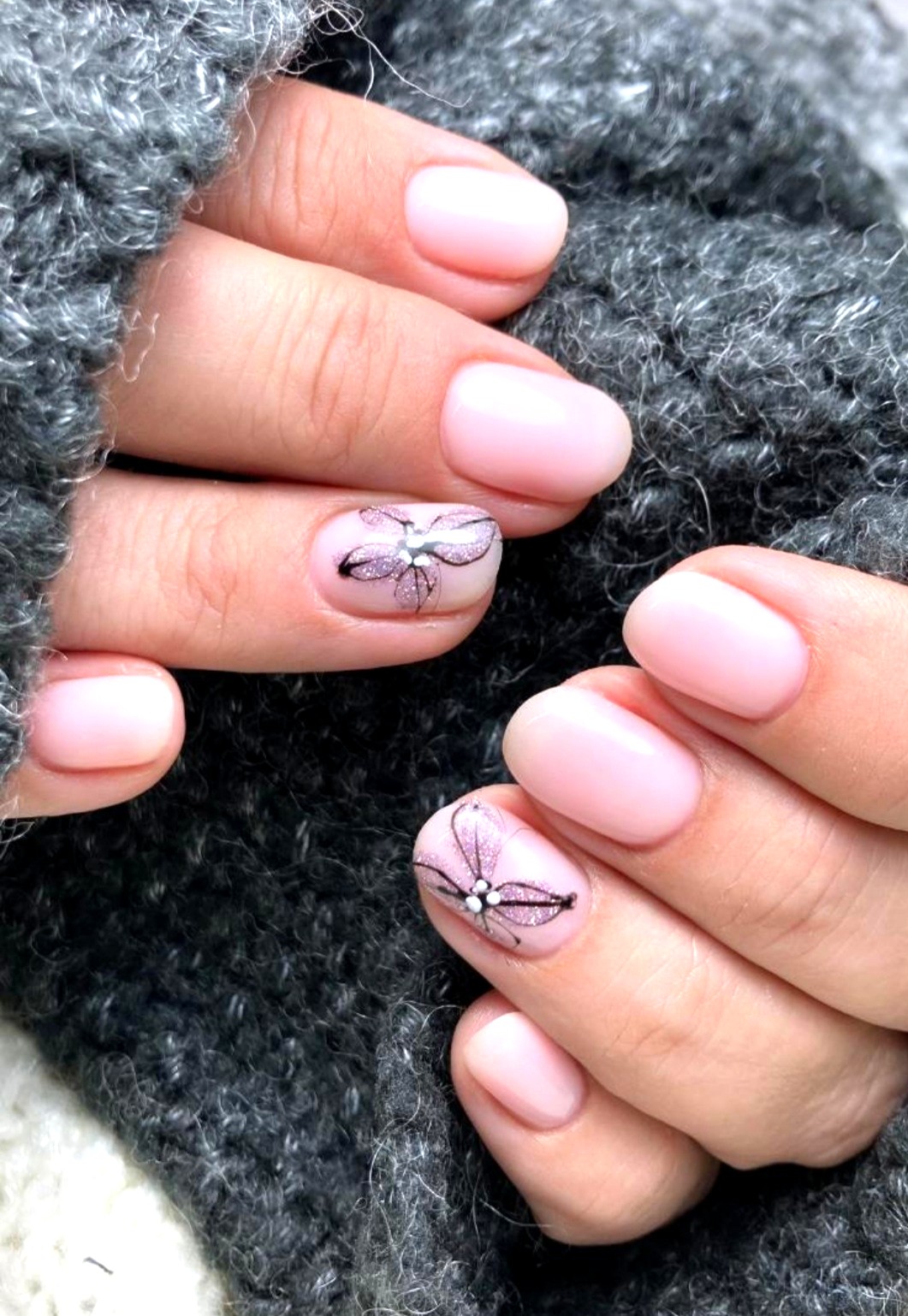 Soft pink manicure with glitter floral accent