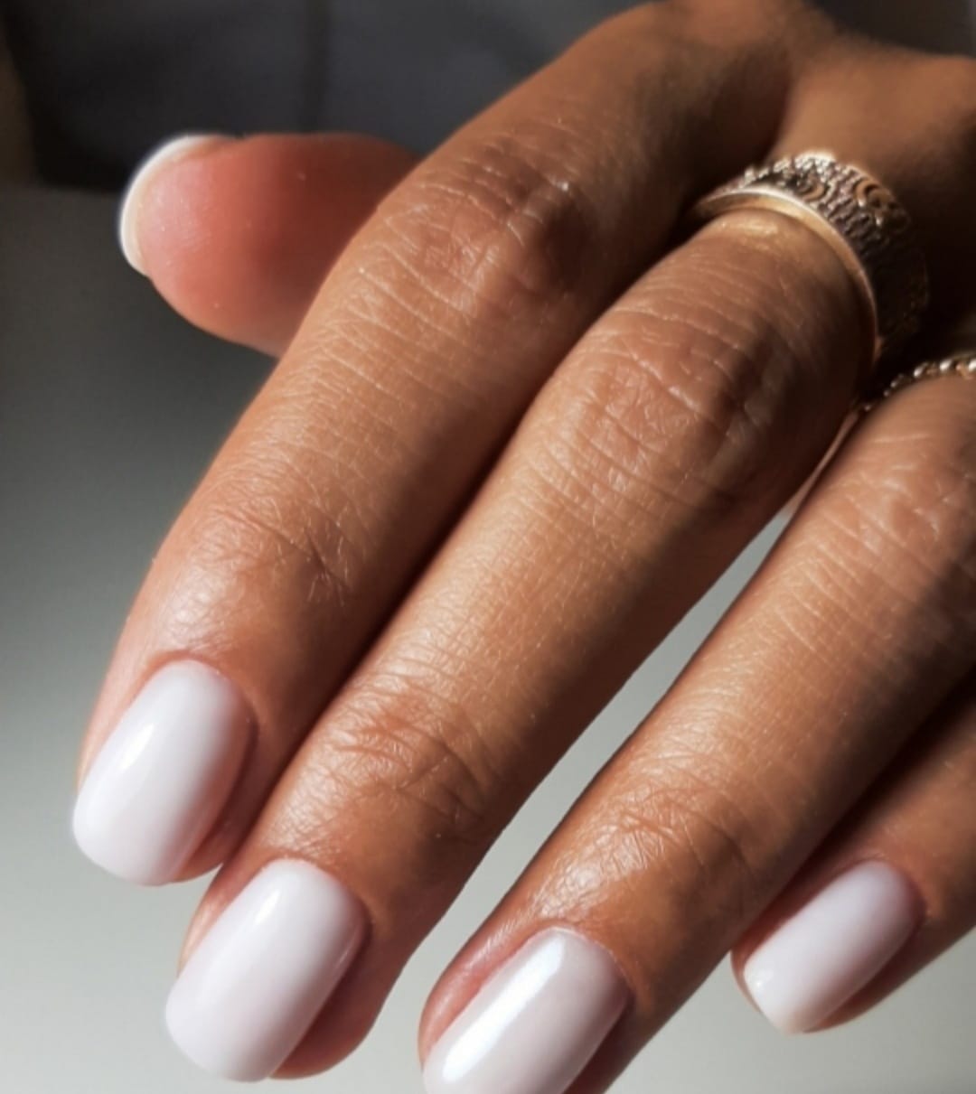 Soft white manicure with gold ring